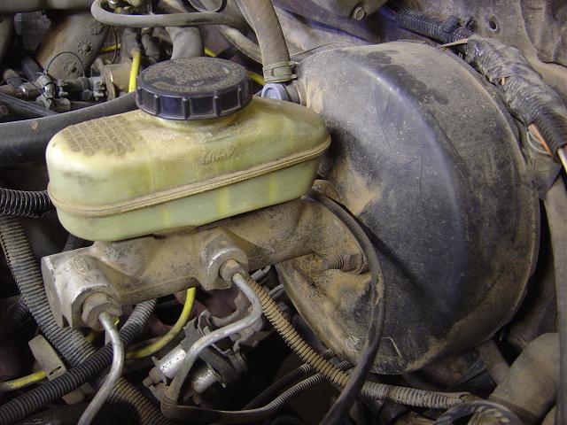 Brake master cylinder and booster assembly with yellow fluid reservoir