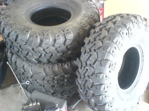 1967 Ford Bronco - Several large, knobby off-road tires are stacked together, suggesting preparation for terrain.