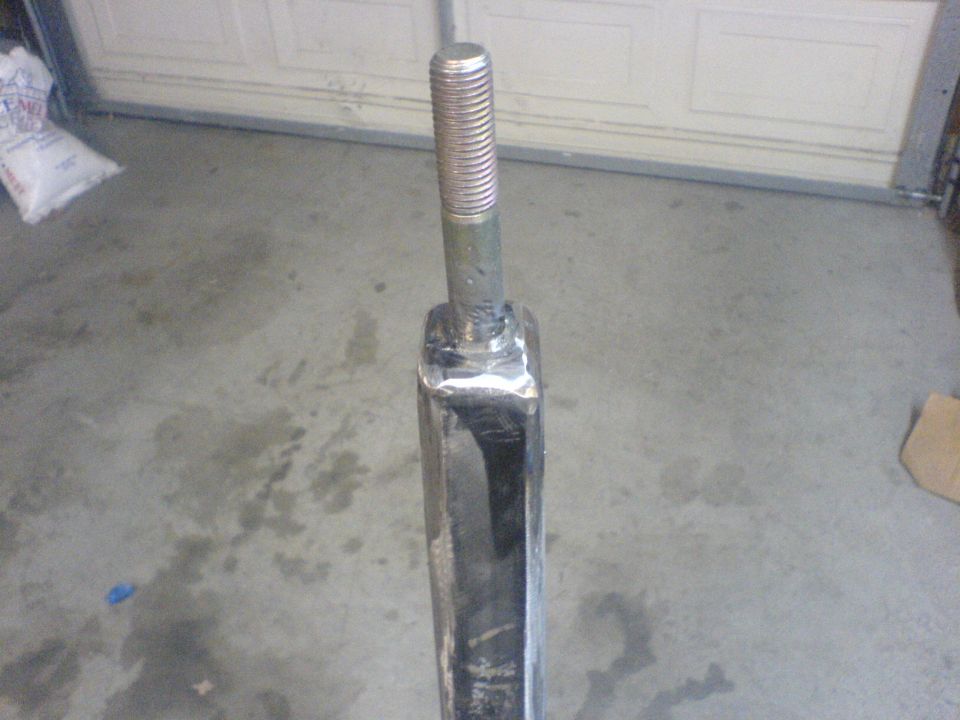 Close-up of a metal suspension part with a threaded bolt