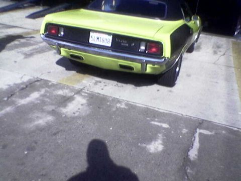 1988 Ford Bronco - A yellow car with black accents is parked on an asphalt surface, seen from a rear angle.