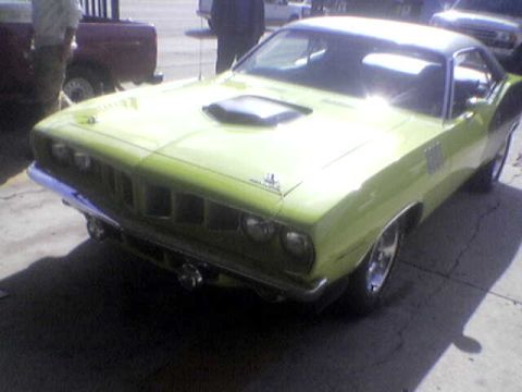 1988 Ford Bronco - This lime green muscle car features a prominent hood scoop and classic styling, captured from a 3/4 front perspective.