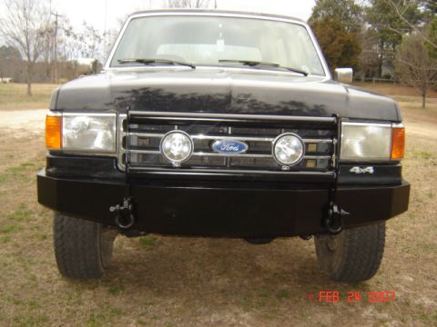 1990 Ford Bronco - Black Ford Bronco with an aftermarket bumper and grille lights is shown from the front.
