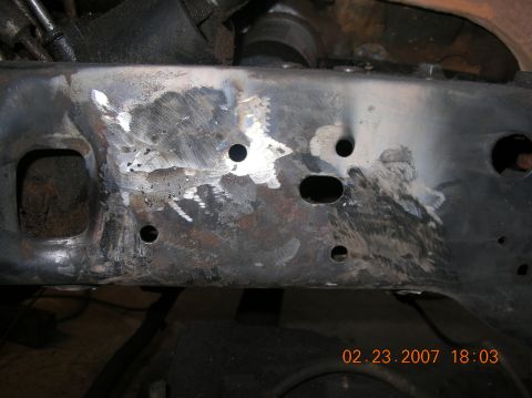 1991 Ford F-150 - Close-up of a heavily repaired vehicle frame, showing extensive welding and grinding.