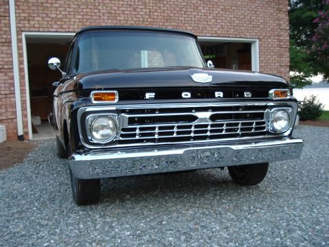 1966 Ford F-100 - Front view of a black 1965 Ford F-100 truck with a chrome grille and round headlights.