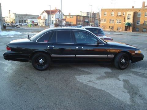 1992 Ford Crown Victoria - Side profile of a black 1992 Ford Crown Victoria parked on an urban street.