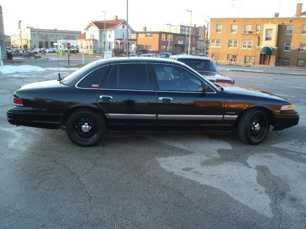 1992 Ford Crown Victoria parked on street, side view. Another car is parked behind it