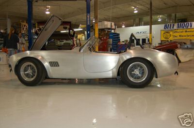 1965 Shelby Cobra - A 1965 Shelby Cobra replica sits in a workshop with its hood open.