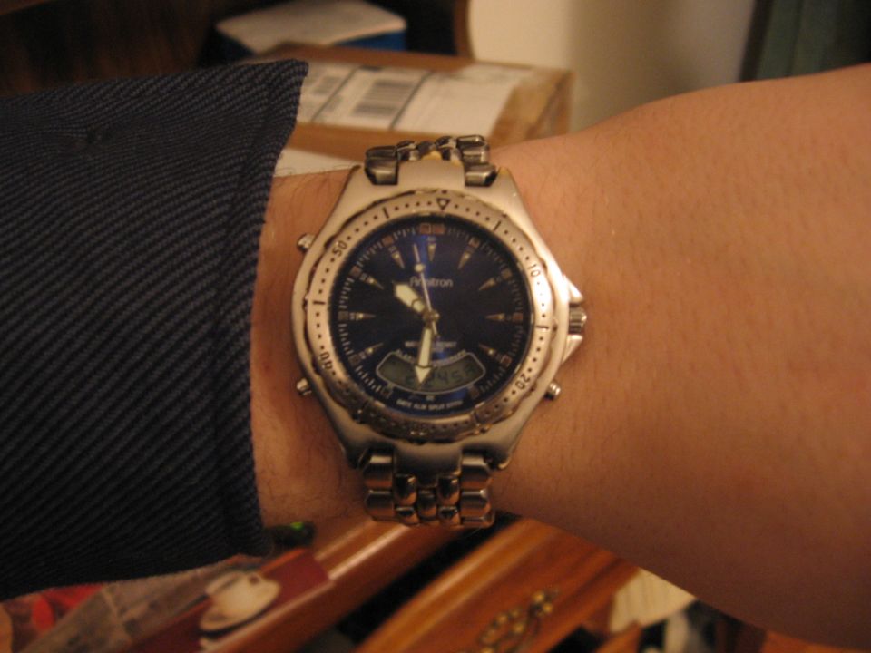 Silver Armitron wristwatch with blue dial worn on a wrist