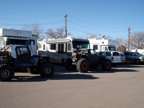 1996 Ford Bronco - Custom off-road vehicles and RVs are parked in a lot on a sunny day.