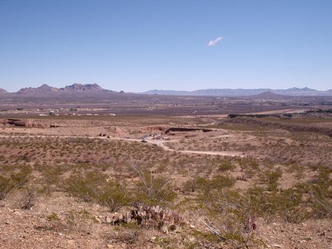 1996 Ford Bronco - A wide view of a desert area with a construction site visible in the middle ground, showing multiple vehicles and activity.