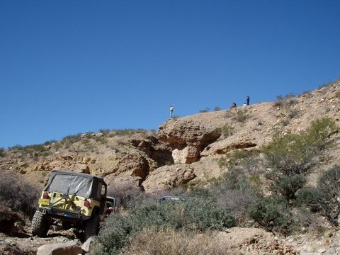 1996 Ford Bronco - Off-road vehicles navigate a challenging rocky terrain under a clear blue sky.