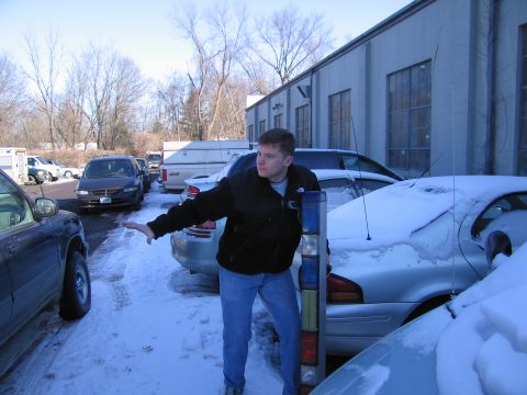 1991 Ford Crown Victoria LTD - A man stands in a snowy parking lot, gesturing towards several parked vehicles.