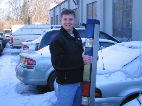 1991 Ford Crown Victoria LTD - A man stands in a snowy parking lot holding a light bar, with several cars visible in the background.