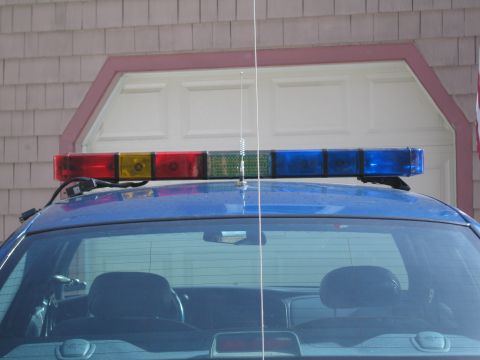 1991 Ford Crown Victoria LTD - Rear view of a police car showing the light bar and antenna on the roof.