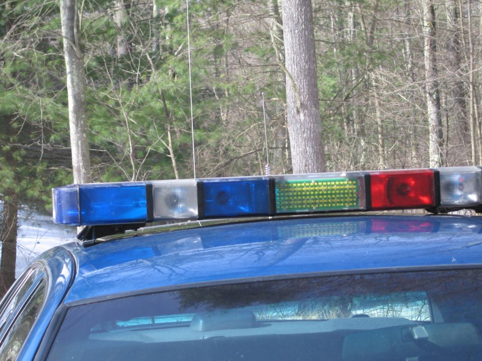 Blue police car roof with light bar showing red, blue, and green lights