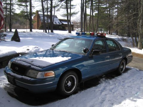 1991 Ford LTD Crown Victoria - Police car with light bar sits in the snow during winter.