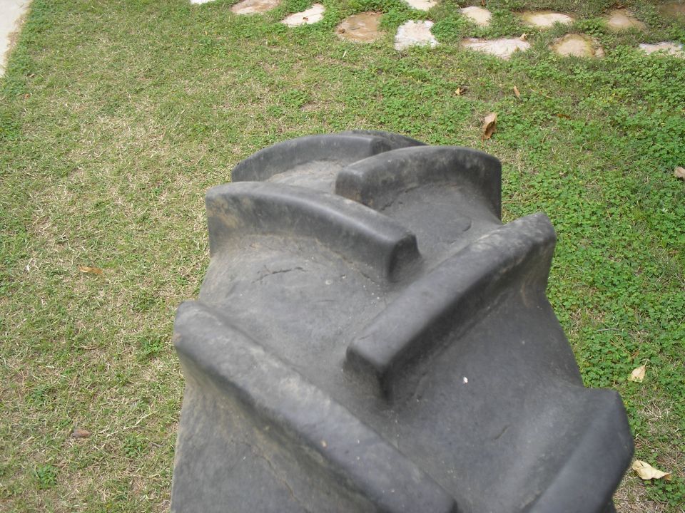 Tire with aggressive tread pattern, black rubber, outdoors on grass