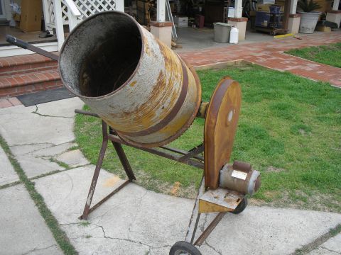 1990 Ford Bronco - Old cement mixer with visible rust and wear, sitting outdoors on a paved area.