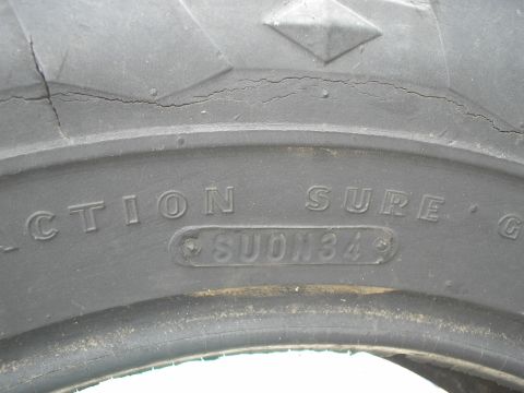 1990 Ford Bronco - A close-up view of a tire's sidewall reveals text including 'TRACTION SURE' and 'SUON34'.