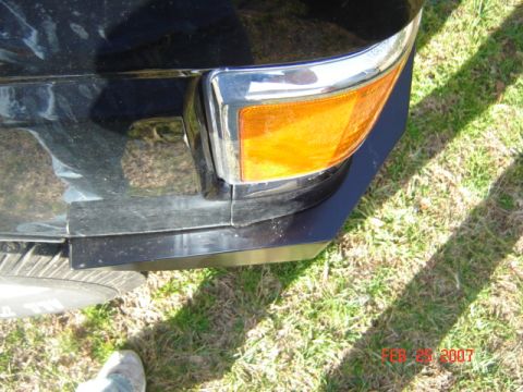 1990 Ford Bronco - Close-up of a vehicle's front corner, showing the bumper and turn signal assembly.