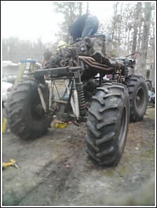 2004 Jeep Wrangler - Monster truck chassis being worked on, showing large tires and engine assembly.