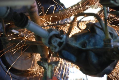 1996 Ford Bronco - Sparks fly as a driveshaft and differential are worked on, suggesting mechanical repair or modification.