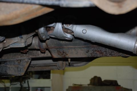 1996 Ford Bronco - Underside view of a vehicle's driveshaft and differential, with visible rust and wear on components.