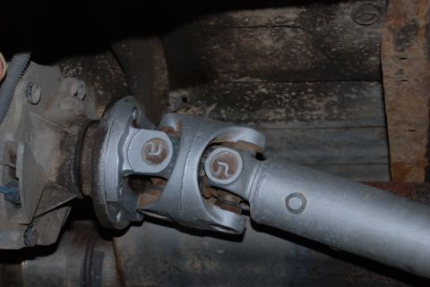1996 Ford Bronco - Close-up view of a vehicle's driveshaft and universal joint, highlighting mechanical components.