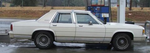 1991 Ford Crown Victoria LTD - A white sedan with a vinyl roof is parked at a gas station.