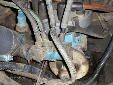 1979 Ford Bronco - This image shows a close-up view of various engine components, including hoses and wiring, with some visible dirt and grime.