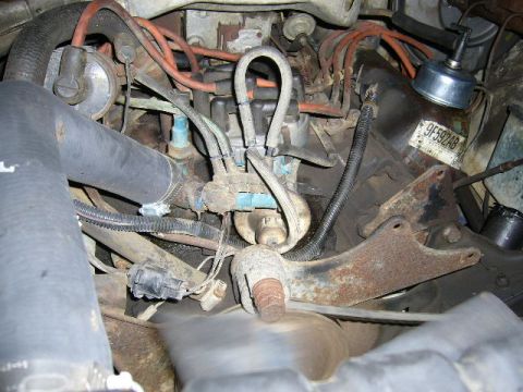 1979 Ford Bronco - Close-up view of a vehicle's engine compartment, showing various hoses, wires, and mechanical components.
