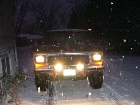 1979 Ford Bronco - A black 1978 Ford Bronco is seen from the front in a snowy environment at night.