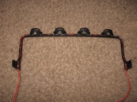 1990 Ford Bronco - A light bar with four lights and red wiring is shown against a carpeted background.