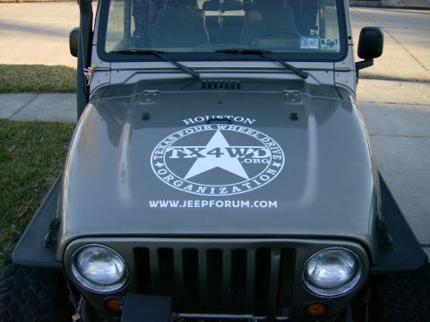 2004 Jeep Wrangler - Front view of a gray Jeep Wrangler's hood, adorned with a prominent "Texas Four Wheel Drive Organization" decal.