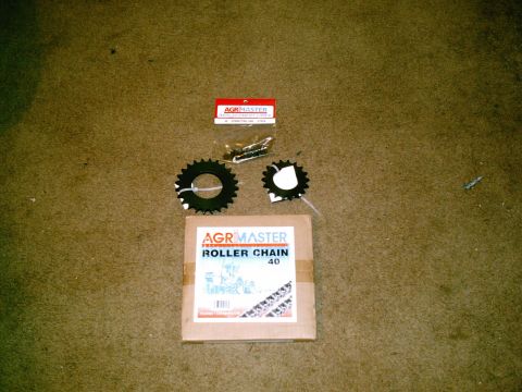 2001 Dodge 2500 - A box of AGRMASTER roller chain, two sprockets, and a small bag of hardware are laid out on a carpeted surface.