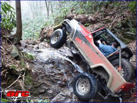 1992 Ford Mustang - An off-road vehicle navigates a challenging, wet, and rocky trail, its off-road capabilities.