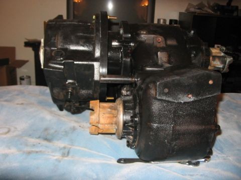 1991 Ford Bronco - A black metal automotive part is shown on a blue cloth, supported by a wooden block.