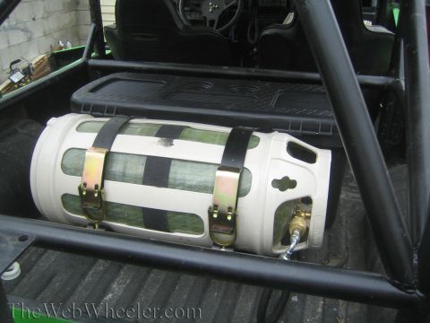 1987 Suzuki Samurai - A propane tank is secured in the rear of a vehicle, with the interior and roll cage visible.