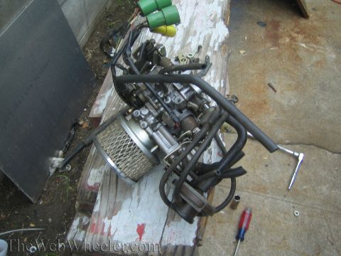1987 Suzuki Samurai - Carburetor assembly and air filter unit, likely removed from a vehicle for maintenance or repair.