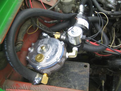 1987 Suzuki Samurai - Close-up of a propane converter and solenoid valve assembly, likely part of a vehicle's fuel system.