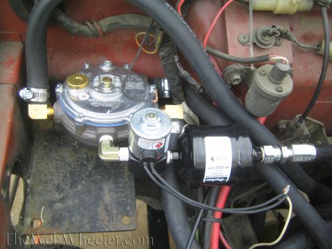 1987 Suzuki Samurai - Close-up view of a vehicle's propane conversion system, showing various components and hoses.