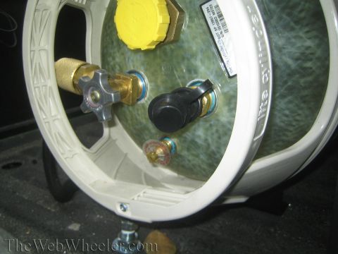 1987 Suzuki Samurai - A propane tank with various fittings is shown up close.