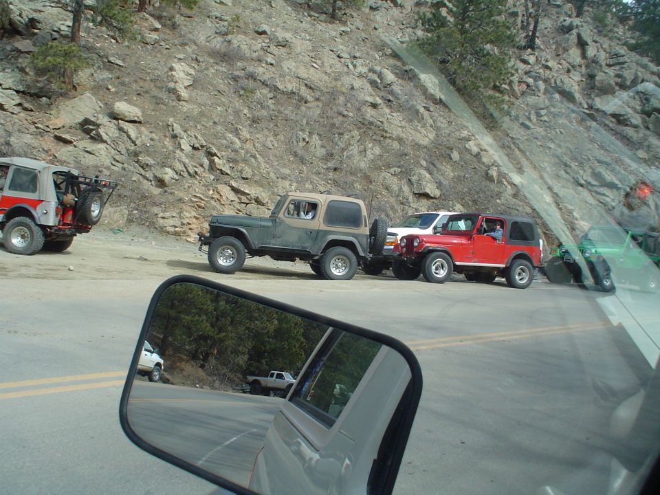 Two Jeep CJ/Wrangler vehicles parked on a rocky mountain trail