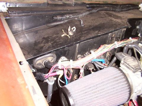 1986 Ford Bronco - Close-up view of a vehicle's engine bay, showing wiring and an air filter.
