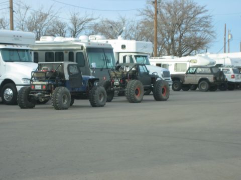 1996 Ford Bronco - Several vehicles, including custom off-roaders and RVs, are parked in an outdoor lot.