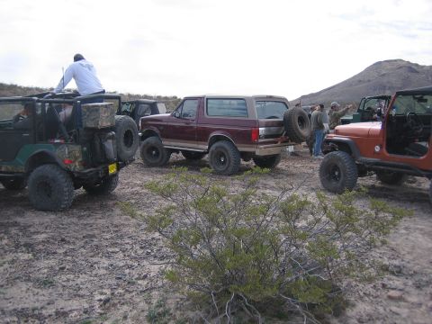 1996 Ford Bronco - A group of off-road vehicles, including a 1996 Ford Bronco, gathered in a desert landscape.