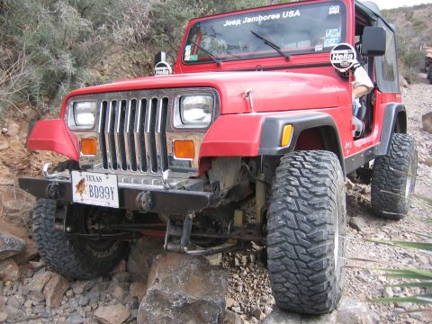 1996 Ford Bronco - This red Jeep Wrangler is navigating a rocky trail, with a "Jeep Jamboree USA" sticker on the windshield.