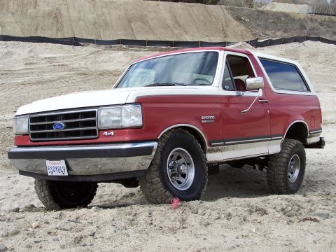 1989 Ford Bronco - This 1989 Ford Bronco features a two-tone red and white paint scheme and 4x4 badging.