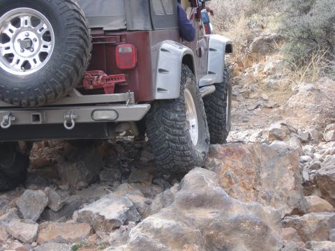 1996 Ford Bronco - This Jeep Wrangler TJ is navigating a rocky off-road trail, demonstrating its capability on challenging terrain.