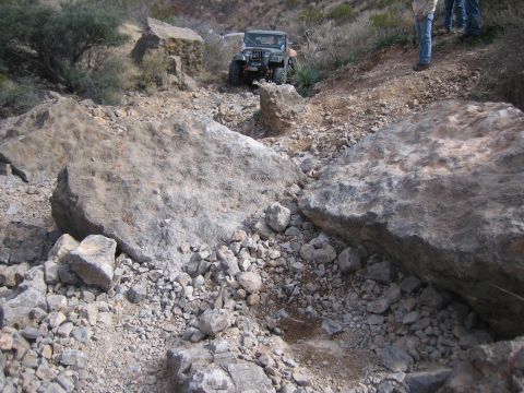 1996 Ford Bronco - A Jeep Wrangler navigates a rocky, off-road trail.